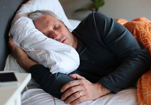 tinnitus sufferer undergoing sound stimulation whilst sleeping